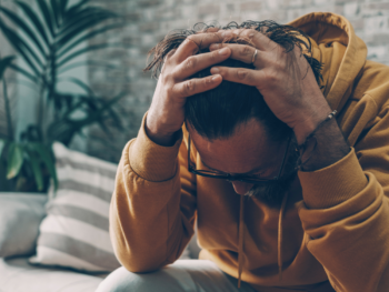 Man sitting quietly with hands clasped, reflecting the internal struggle of performance anxiety erectile dysfunction {{brizy_dc_image_alt entityId=