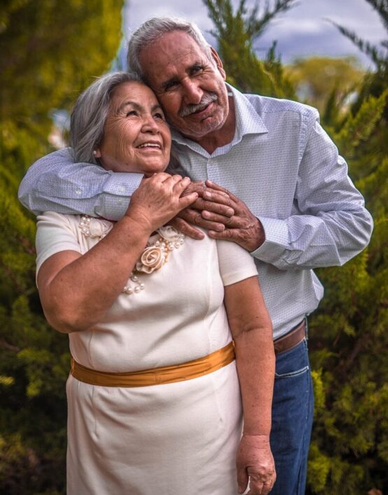 man in white dress shirt hugging woman in white dress