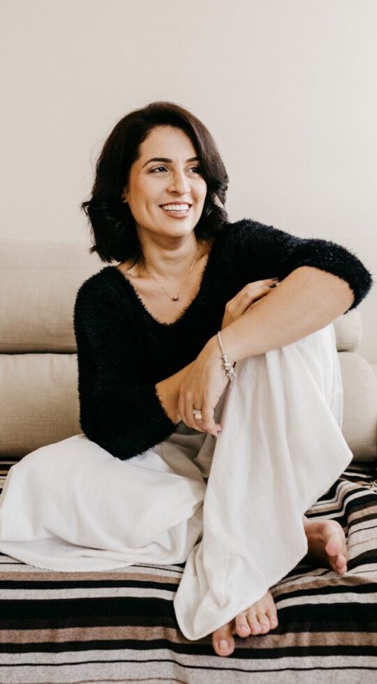 woman in black long sleeve shirt sitting on white couch